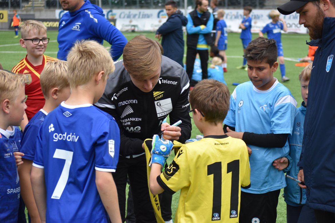 Unge fotballspillere fra Våg og Vindbjart sikrer seg autografen til Adnan Hadzic.