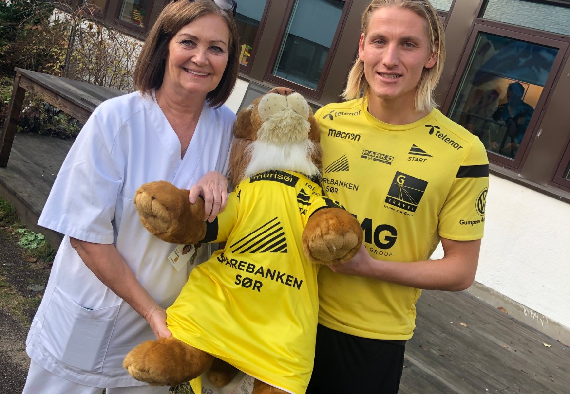 Kaptein Erlend Segberg ga enhetsleder Turid Stadheim ved barneposten på Sørlandet sykehuset en store løve (fra Dyreparken), ikledd en Start-drakt.