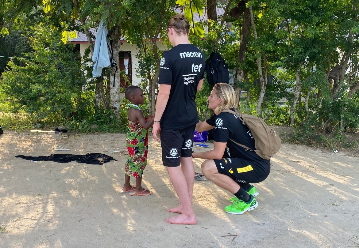 Mikael og Erlend møter en liten gutt på besøk hos en familie i Tanzania.