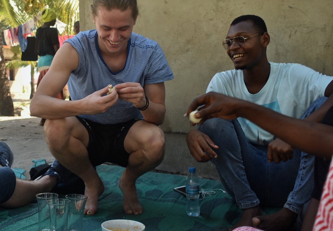 Mikael på middagsbesøk hos en familie. Måltidet ble spist ute, på et teppe på bakken. Familien bodde på ett rom, men de var heldige som delte utedo og brønn med naboene i landsbyen.