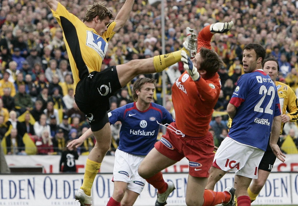 Marius Johnsen,i kamp med VIFs målvakt Arni Gautur Arason. Ronny Johnsen følger spent med på om det blir mål.